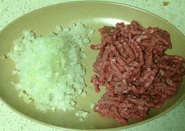 芝士牛肉堡,口中含清水(防止切的时候流泪),将洋葱横对切,取最外圈的洋葱圈备用,其余切末;