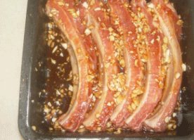 蒜香叉烧排骨,将腌肉料倒入,均匀涂抹在小肋排上面。