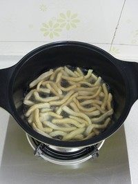 蔓越莓沙琪玛,锅里倒油烧至七八成热,把面条分次入锅炸至颜色微黄后捞出控油。