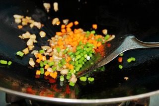 自制豆腐花,加入胡萝卜、蒜苗粒一起煸炒,加入盐,美极鲜,酱油炒匀