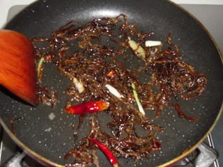 梅菜蒸汪刺鱼,起油锅,放入葱白、干辣椒、八角爆香,放入梅干菜翻炒一会儿
