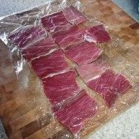 菲律宾甜猪排饭,上面再覆上一层保鲜膜,用拍肉排的工具,或者擀面杖把肉轻轻的敲松一点点,不要敲太薄。