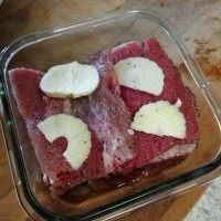 菲律宾甜猪排饭,将肉片每面沾上佐料粉,然后铺在碗里,上面放上一片蒜片,上面在放上另一片沾好的肉末,全部放好后,密封放入冰箱,腌最少12个小时,最好是2天时间。