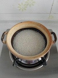 腊味煲仔饭,在砂锅底部抹一层油,再将泡好的大米沥干水放入砂锅,倒入清水(水要超过大米约1cm)。盖上锅盖中小火煮开后再焖煮10分钟左右。