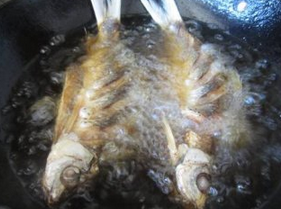 豆豉鲮鱼,炸锅里油烧热,将鲮鱼炸透到两面金黄,捞起沥油。