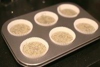 三重黑芝麻杯子蛋糕,模具中放入纸模具,将面糊均匀倒入模具,轻磕去除大气泡。