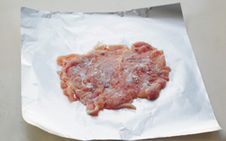 糯米鸡肉卷,将鸡腿肉铺在锡纸的亚光面上,撒少许干淀粉。