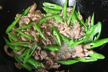 杭椒牛柳,倒入杭椒翻炒十来下后，倒入牛肉，加黑胡椒碎和少许盐调味(如果你腌肉的料够重，可不用再加盐)，略翻炒(不要久炒，速战速决)后撒上<a style='color:red;display:inline-block;' href='/shicai/ 141911'>熟白芝麻</a>(没有也无所谓)即可出锅．