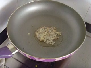 九层塔炒花蛤,锅烧热后放入少许油,姜蒜切末,放入锅中爆香。