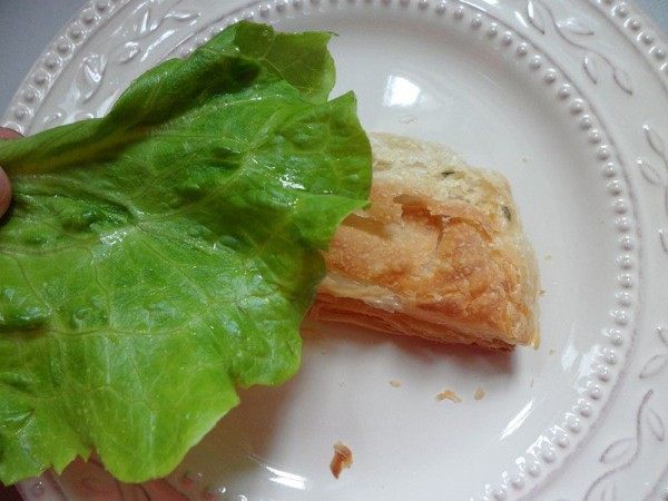 法风烧饼,取一块烤好的飞饼,用手轻压一下,放上生菜