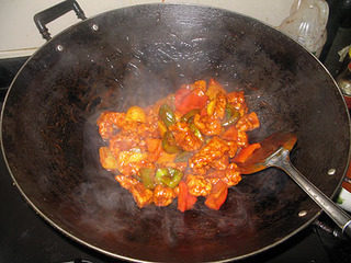 咕噜肉,加入炸好的猪肉后,快速炒匀,令每块猪肉都裹上糖醋汁。