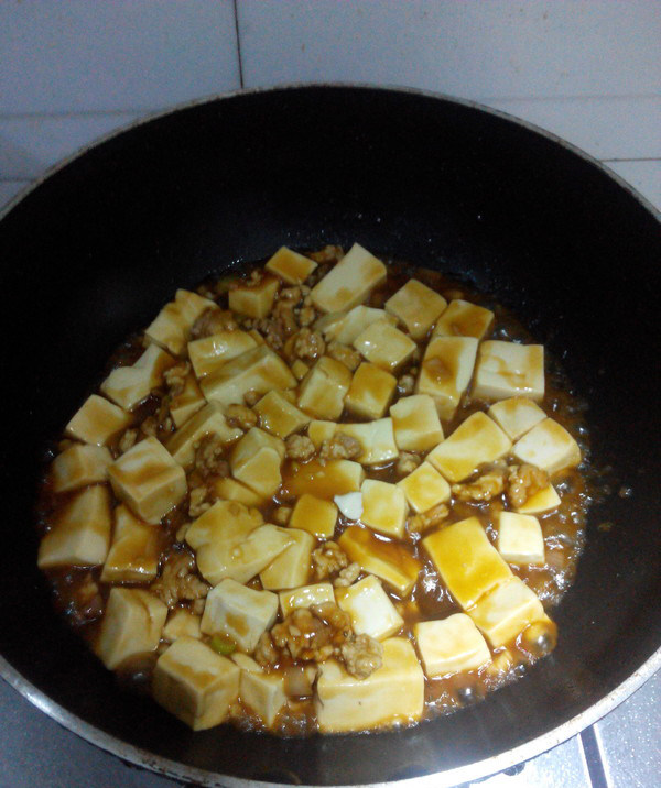 肉末豆腐,下入豆腐,晃动炒勺,使汤汁均匀的包裹在豆腐上,盛出装盘,撒上<a style='color:red;display:inline-block;' href='/shicai/ 131'>香菜</a>段即可