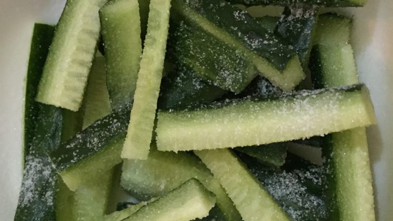 酸辣瓜条,如图撒上适量盐,腌制一个半到两个小时,中间将腌制出的水倒掉,反复两到三次。