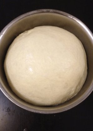 椰蓉面包,当面团膨胀至原来两倍以上大，手指沾<a style='color:red;display:inline-block;' href='/shicai/ 28205'>高粉</a>插入后小洞不回弹，基础发酵结束。将面团取出分割成所需的份量后滚圆，盖保鲜膜松弛15分钟。