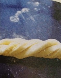 椰蓉面包,两手分别捏住面团两头向反方向卷2-3下，然后打个结，放在模子中，放温暖湿润处发酵。