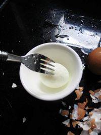 当归鸡蛋红糖水,取出,用冷水泡浸一下,剥去鸡蛋壳,并用叉子在蛋白的表面扎一下。