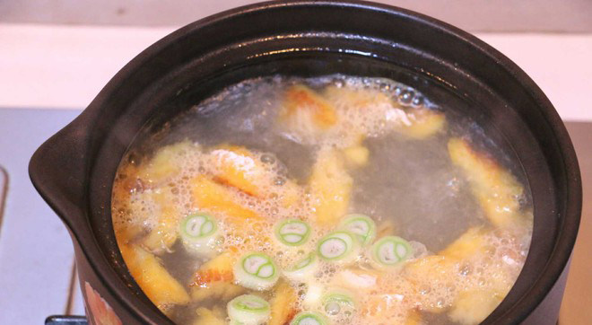 黄豆芽明太鱼汤,沸水中加入炒好的明太鱼和葱,继续煮5分钟