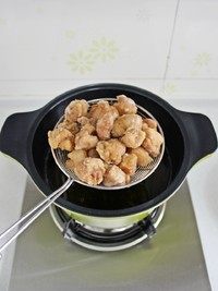 菠萝咕咾肉,锅里倒油,烧至八成热,将肉块入锅炸至定型后捞出,将锅里的油再次烧至八成热,肉块下锅复炸至肉块表面金黄后捞出控油。
