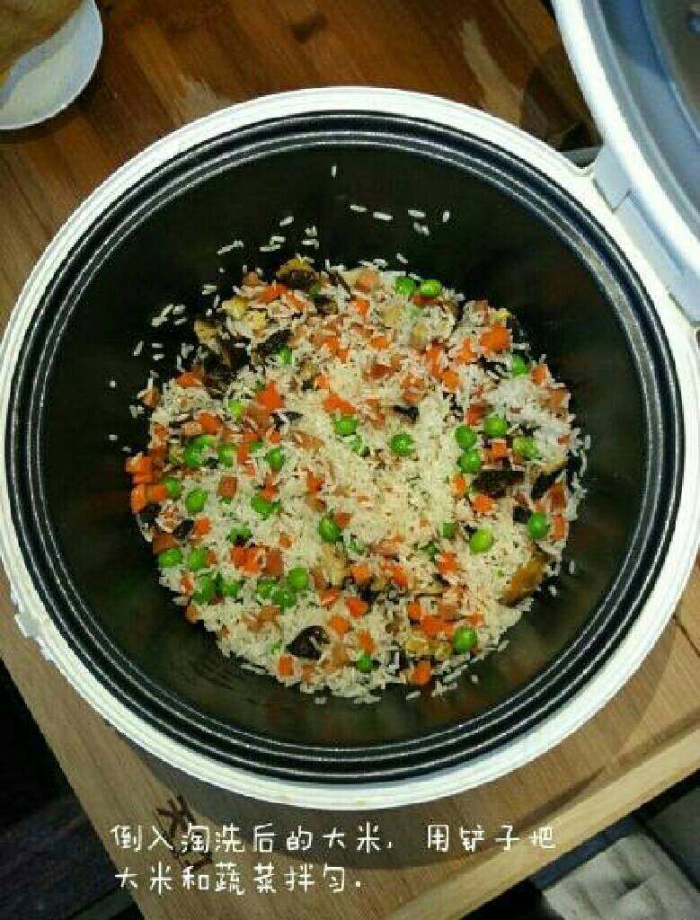 什锦焖饭,倒入淘洗后的大米,用铲子把大米和蔬菜拌匀