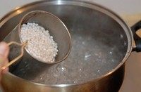 椰汁西米糕,锅中煮沸一锅水,下入西米,不停搅拌