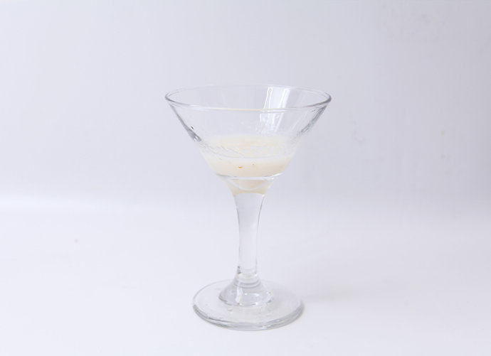 双色荔枝果冻,准备一个干净的玻璃杯,舀取1勺步骤4中的荔枝溶液,倒进杯子里三分之一处,放入冰箱冷藏15分钟至凝固。