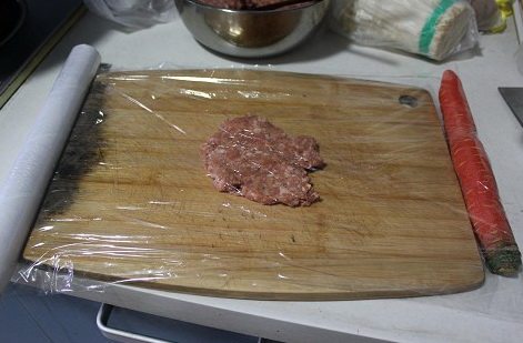 自制猪肉脯,肉分成6份,夹在保鲜膜中间,擀面棒轻轻擀平,胡萝卜是为了固定保鲜膜,擀好后可以轻松取出