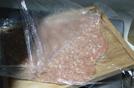 自制猪肉脯,6片都擀好,垒一起冷冻2小时,下面要有一个平整的托盘,每片中间用纸巾隔开,防止保鲜膜冻得粘连