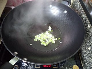 番茄豆腐,锅内放油烧热,小火爆香葱花。
