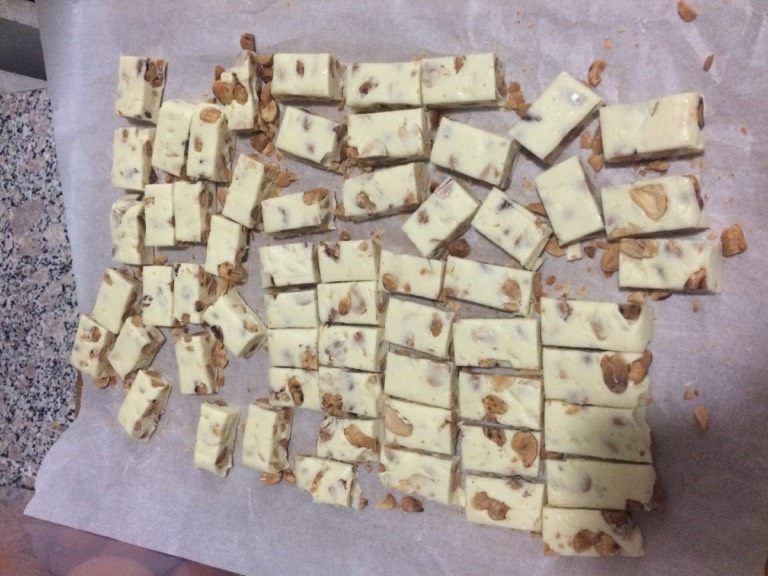 牛轧糖,压好后拿出,先切成长条,在按照糖纸的大小切成小块