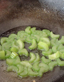 西芹百合酿虾球,锅入油,用手放置油上稍有热度就将西芹倒入,快速翻炒。
