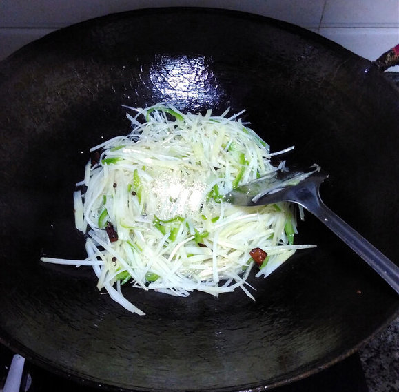 家常土豆丝,食材都炒熟后，调入适量盐，鸡精，翻炒均匀