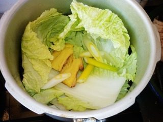 酥锅,高压锅洗净上灶,开始码菜,把料盒放在最下面,首先如图铺上<a style='color:red;display:inline-block;' href='/shicai/ 114'>白菜</a>,葱姜。