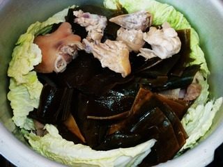 酥锅,再放肉,猪蹄,鸡块,鱼;再放一层藕片,海带,最后放上葱花,姜片,撒2勺糖,两勺半盐,300ml醋,300ml酱油,100ml清水,再盖上一层白菜。