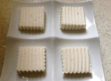 翡翠蒸豆腐,如果用碗也可以,尽量切成不超过1CM厚的,用牙签在豆腐上扎几个孔,少少撒上一点盐,放置十分钟,倒去渗出的水份;