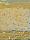 红蟹籽鳗鱼寿司里卷,先将标准尺寸<a style='color:red;display:inline-block;' href='/shicai/ 279'>海苔</a>铺满米饭,米饭上盖一层保鲜膜,并翻转过来,使米饭一面向下