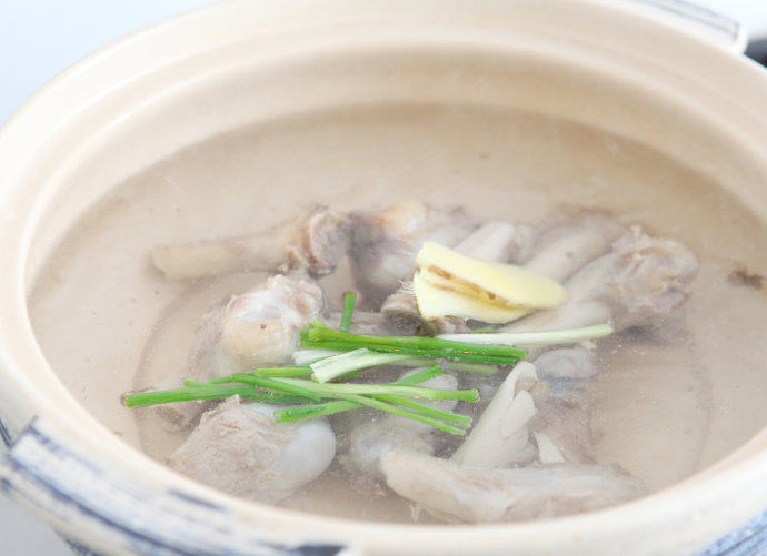 羊肉粉丝汤,砂锅中下入羊骨头,加葱段、姜片,加入大半锅清水。