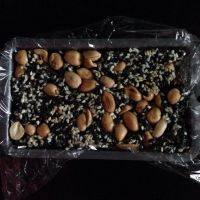 花生芝麻糖,倒入铺保鲜膜的容器内，紧压实。