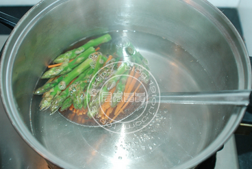 培根蔬菜卷,锅中水烧开, 放一小勺盐,入胡萝卜条和芦笋条煮两分钟,捞出沥干水分