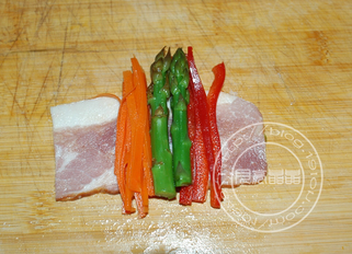 培根蔬菜卷,把培根平铺,放上胡萝卜条,芦笋条和彩椒条