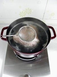 蘸汁肘花,锅里加凉水,放入猪肘,大火烧开后用漏勺将浮沫撇净。