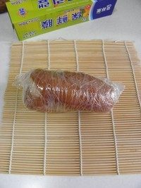 蘸汁肘花,用保鲜膜将猪肘肉卷成卷,卷好的猪肘放冰箱冷藏至彻底变凉。