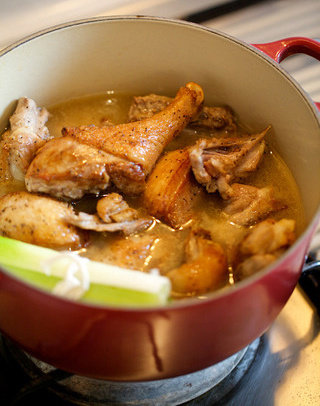 甜杏萝卜炖鸭,加入高汤,放回鸭肉,加入香料束,盐和黑胡椒调味。加热至沸腾,随后移入烤箱或小火炖煮45分钟