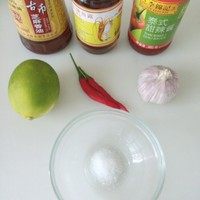 泰式凉拌鱿鱼,准备调料。青柠挤出汁,朝天椒切圈,蒜捣碎,将所有调料拌在一起。