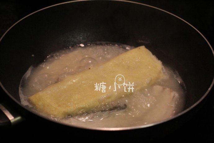 富贵庆余年,焯水过后的鱼骨加到羊肉汤中煮开,再加入步骤21的半成品鱼糕卷煮大约20分钟