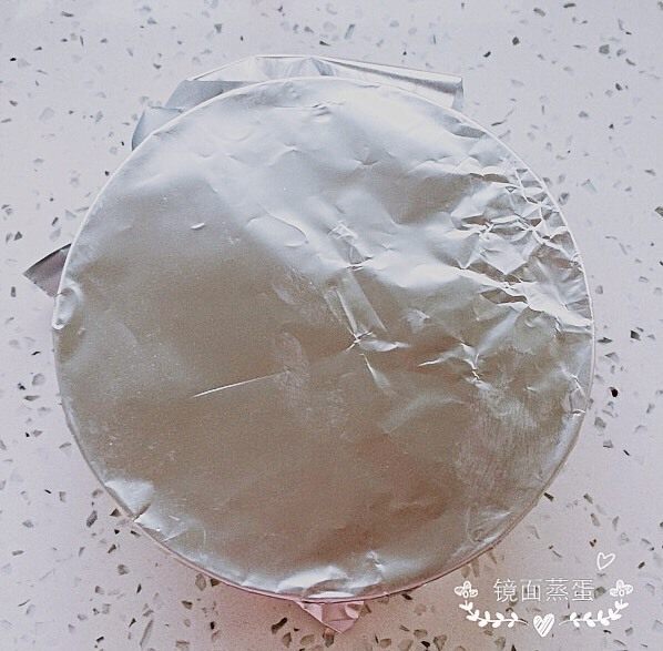 镜面蒸蛋(加火腿),将锡纸覆盖在碗面上,用手沿碗边压紧,拿胶皮筋固定好