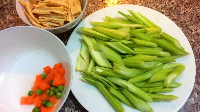 芹菜腐竹,辅助用温水泡软，<a style='color:red;display:inline-block;' href='/shicai/ 125'>芹菜</a>摘掉叶子切成小块，胡萝卜切丁，青豆洗净备用