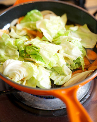 炒面,放入卷心菜和香菇一同翻炒,保持温度,倒入1茶匙<a style='color:red;display:inline-block;' href='/shicai/ 692'>酱油</a>调味,等待卷心菜略微发软时将蔬菜盛出待用
