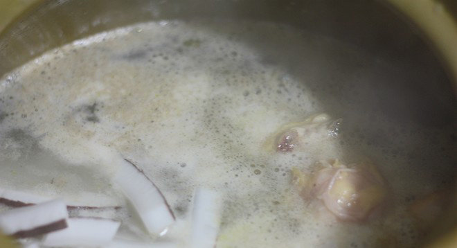 广东椰子鸡汤,汤锅煮沸水后放入椰子肉和鸡块,大火烧开后转小火煲两小时
