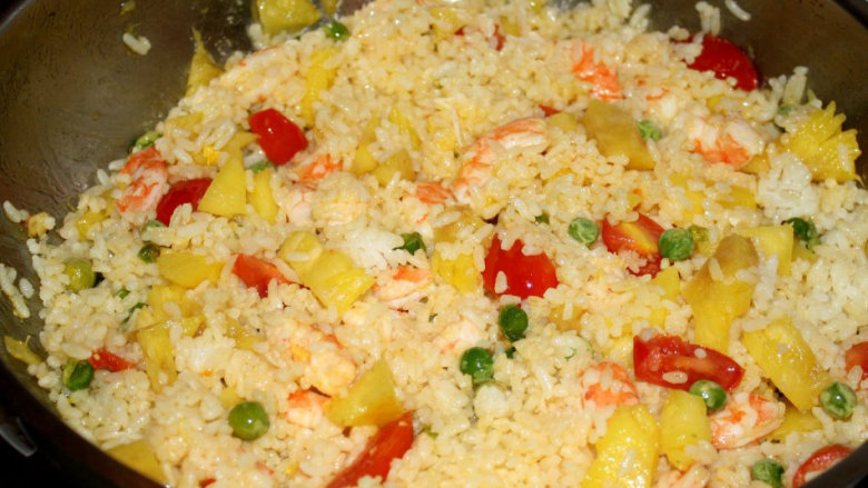 五彩菠萝饭,放入<a style='color:red;display:inline-block;' href='/shicai/ 507'>米饭</a>（较硬）炒均匀，加入盐调味