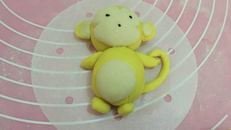 南瓜小猴子馒头,取黄色面团作出两只手和两只脚,一条长尾巴,可爱的小猴子就做好了,放在油纸上锅盖上盖子大火烧开,计时二十分钟即可